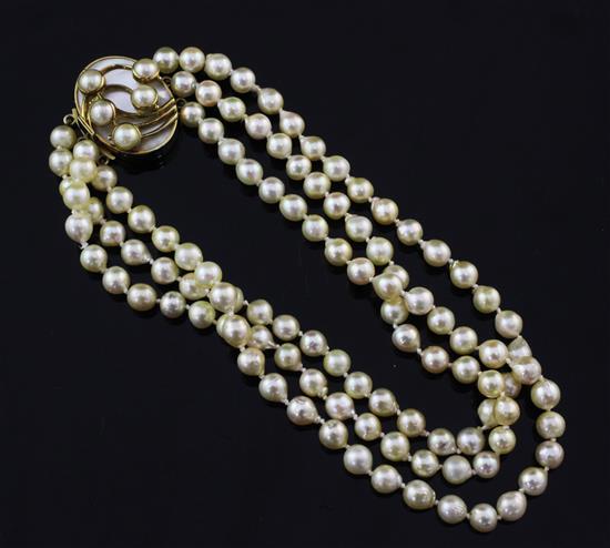 A 1990s triple strand cultured pearl choker necklace with a stylish mother of pearl set 18ct gold clasp, 12in.